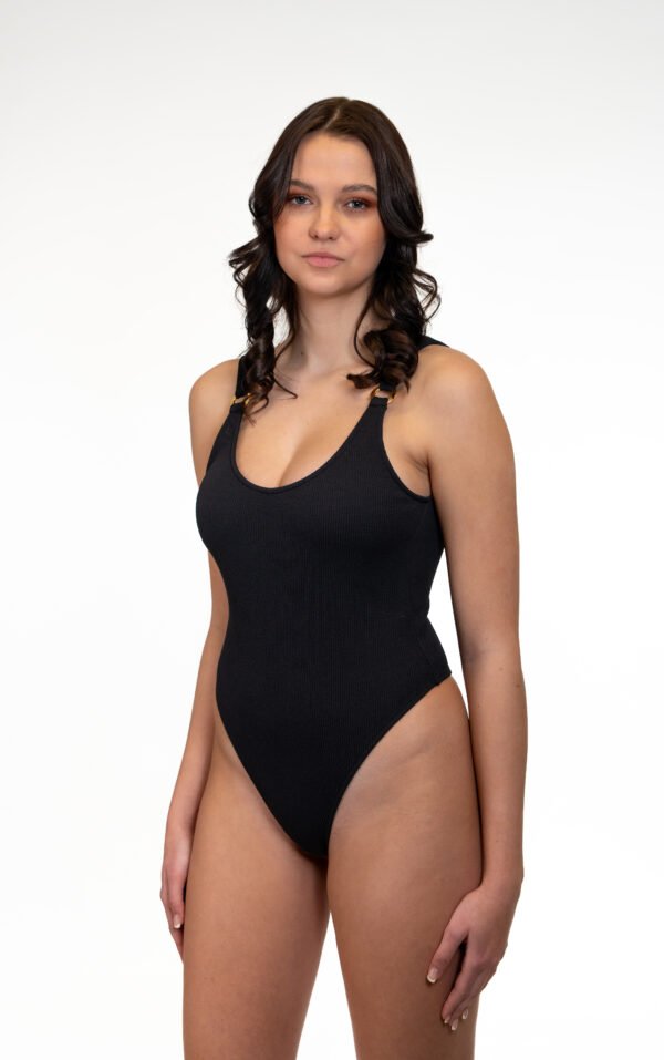 Maillot de bain une pièce Olinda thong en noir avec une coupe haute sur la jambe, un décolleté et un tissu côtelé ultra-doux.